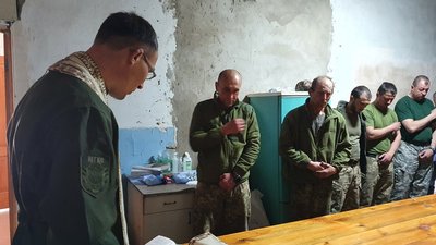 Капелан 128-ї бригади проводить недільну службу для бійців у складському приміщенні