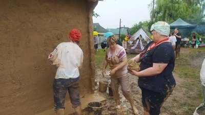 Мажуть глиною хату на Харківщині