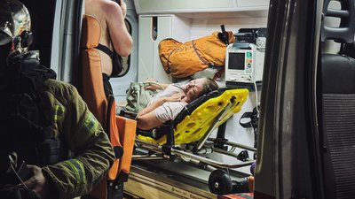 Жінка в швидкій після влучання російського дрона в авто у Київському районі Харкова