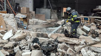 Рятувальник гасить пожежу після влучання безпілотника на відділенні "Нової пошти" в Ізюмі