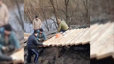 Люди будують дерев'яний переїзд на мосту біля села Снов'янка