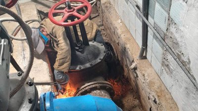 Працівник водоканалу ремонтує водогін