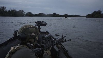 Українські військові пливуть на човні річкою Дніпро на передовій поблизу Херсона