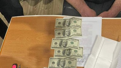 На столі 500 доларів США, що чоловік пропонував поліцейському