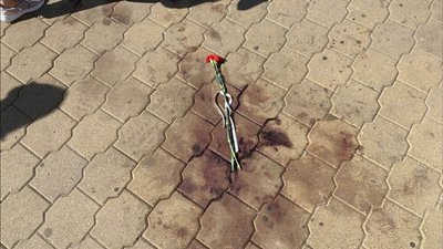 Люди несуть квіти до місця, де загинув протестувальник Люди несуть квіти до місця, де загинув протестувальник