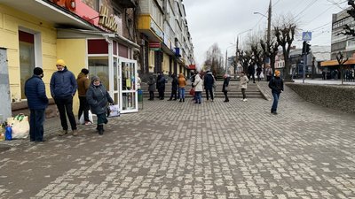 Люди стоять у черзі до банкомату Люди стоять у черзі до банкомату