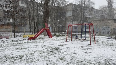 Сніг падає на дитячий майданчик в Миколаєві