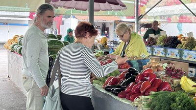 Люди купують овочі на ринку