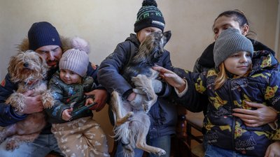Сімʼя в зимовому одязі на кухні квартири у Києві, де немає опалення та гарячої води