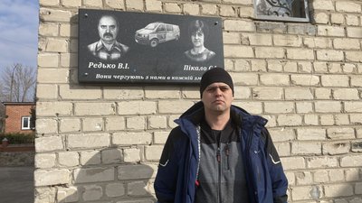 Сергій Редько на фоні меморіальної дошки загиблим Василю Редьку та Світлані Пікало, Чугуїв, Харківська область, березень 2024 року. Сергій Редько на фоні меморіальної дошки загиблим Василю Редьку та Світлані Пікало, Чугуїв, Харківська область, березень 2024 року.