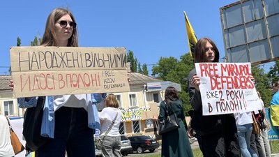 Люди з плакатами на акції протесту