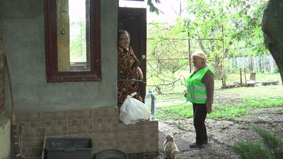 Соцпрацівниця допомагає пенсіонерам по господарству Соцпрацівниця допомагає пенсіонерам по господарству