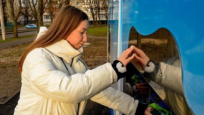 Жінка набирає воду в безплатному бюветі в Харкові