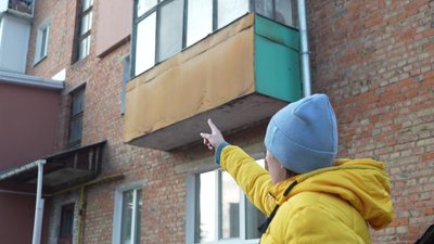 рина Дяденко показує пошкоджений будинок в Сумах.