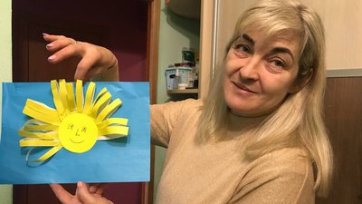 Мати показує одну із творчих робіт сина Мати показує одну із творчих робіт сина