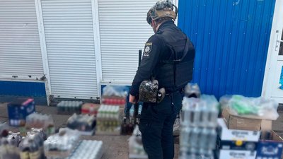 Поліцейський біля алкоголю, який незаконно продавали у Великому Бурлуку на Купʼянщині