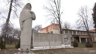 Скульптура жінки в скорботі та дошка з іменами полеглих місцевих мешканців Скульптура жінки в скорботі та дошка з іменами полеглих місцевих мешканців