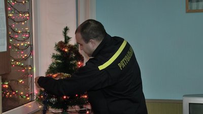 Рятувальник Володимир Ахмедов прикрашає ялинку Рятувальник Володимир Ахмедов прикрашає ялинку