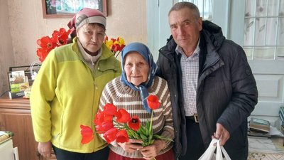 Іменинницю Марію Романюк вітає староста села Володимир Кубський та соціальна працівниця