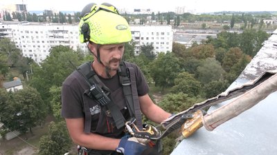 Промислові альпіністи у Харкові закривають вибиті через війну вікна Промислові альпіністи у Харкові закривають вибиті через війну вікна