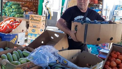 На ринку люди купують огірки ящиками. На ринку люди купують огірки ящиками.