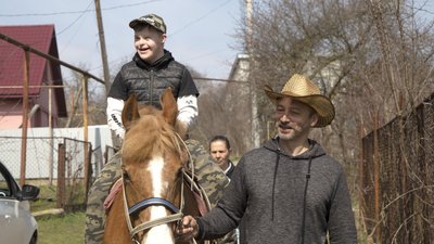 Микола Дичка вчить кататись верхи на коні підопічного центру Микола Дичка вчить кататись верхи на коні підопічного центру