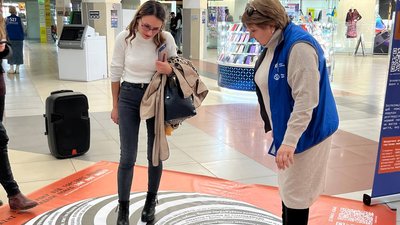 Під час акції люди розглядають ілюзорний плакат Під час акції люди розглядають ілюзорний плакат