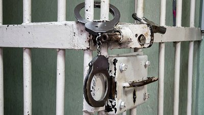 кайданки на клітці в суді