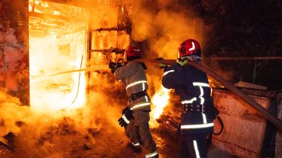 Рятувальники поруч із вогнем, намагаючись його загасити