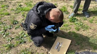 Правоохоронець фотографує ніж, який ймовірно був знаряддям вбивства
