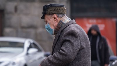Пенсіонер у масці йде вулицею