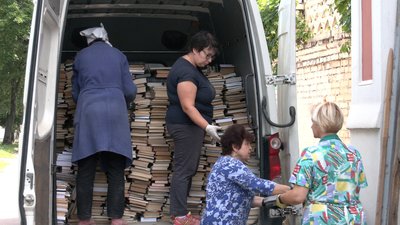 Волонтери допомагають виносити книги Волонтери допомагають виносити книги