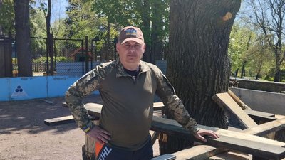 Житомирський військовий на підтримку побратимів вирізає з дерева герб 95 бригади Житомирський військовий на підтримку побратимів вирізає з дерева герб 95 бригади