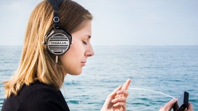 Жінка у навушниках слухає музику 