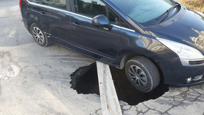 У Тернополі автомобіль провалився у яму на дорозі У Тернополі автомобіль провалився у яму на дорозі