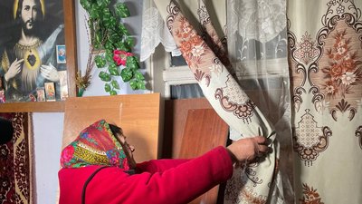 Олександра Нейко показує в хаті вікно, затягнуте плівкою Олександра Нейко показує в хаті вікно, затягнуте плівкою
