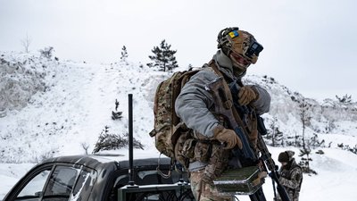 Український військовий зі зброєю в руках в багажнику автівки